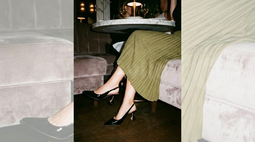 Black patent kitten-heel slingback shoes paired with a pleated midi skirt.